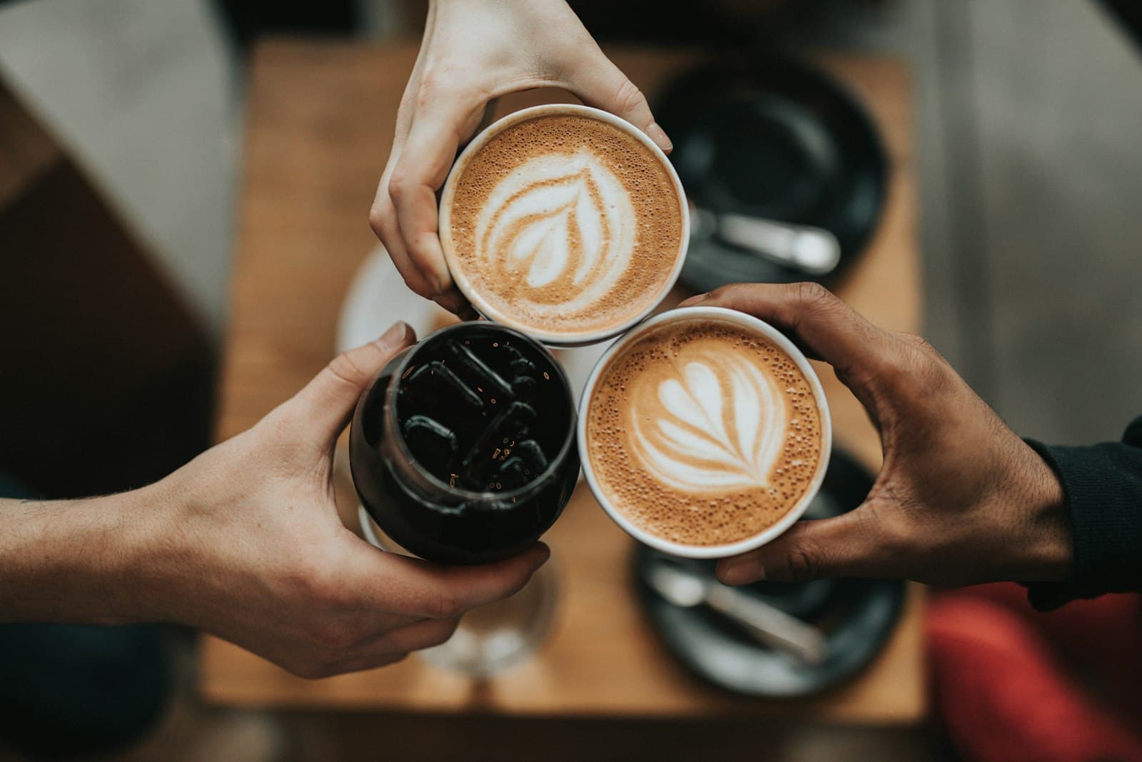 Drei Kaffeetassen mit Latte Art von oben